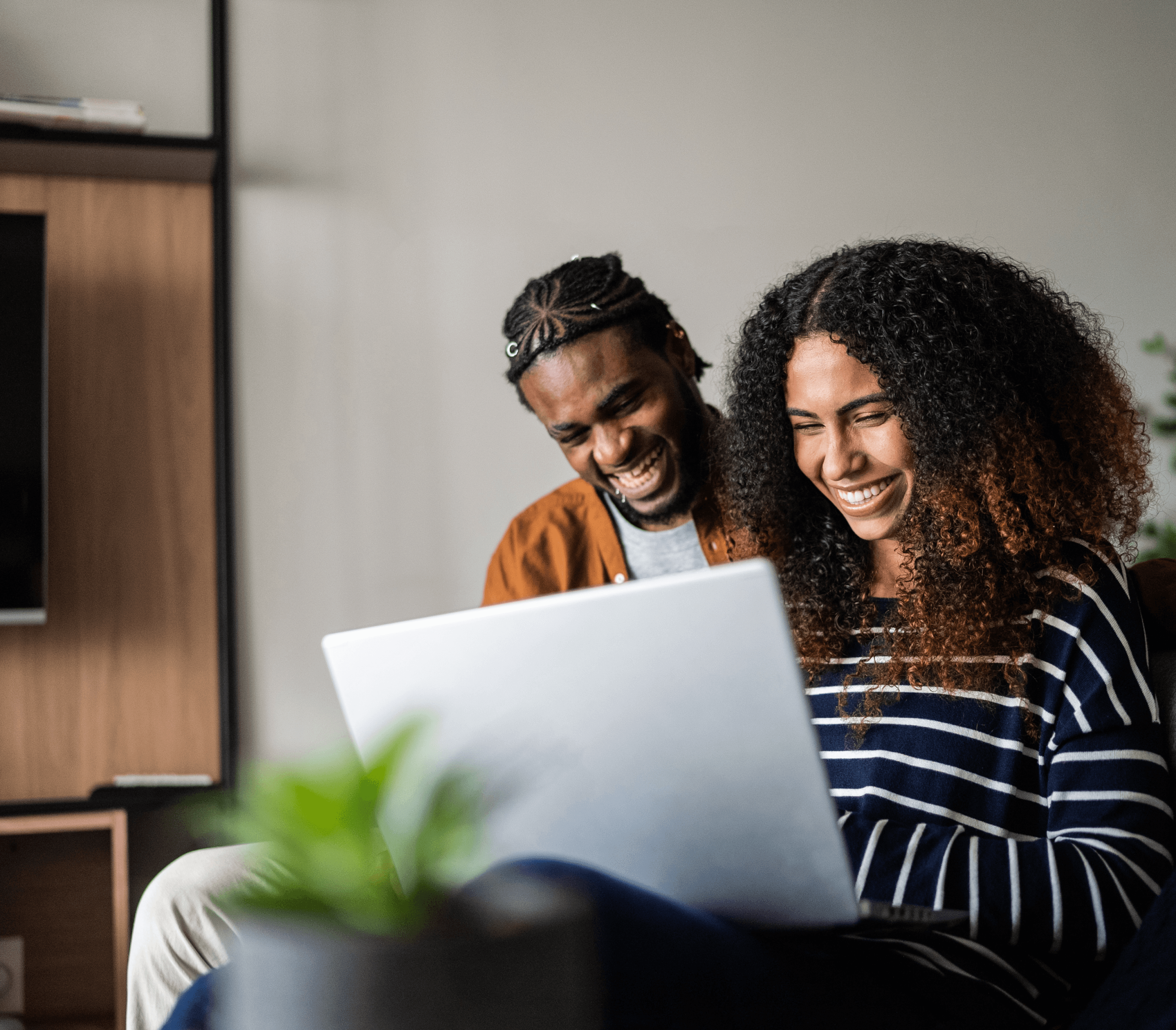 Man and woman smiling while looking at a computer